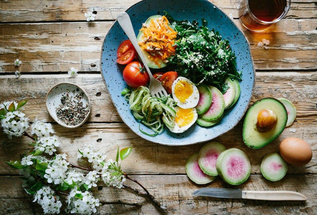 Healthy breakfast plate with egg, greens and avocado